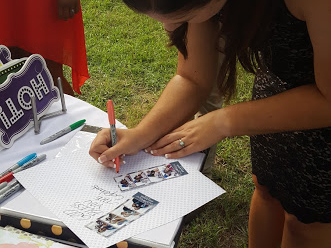 a party guest writes on a scrapbook page