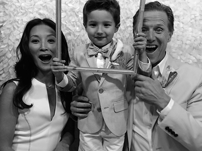 a family with a young son pose for a photo in the picture booth