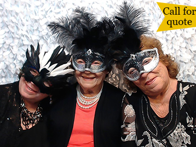 three older ladies pose with masks in the photo booth