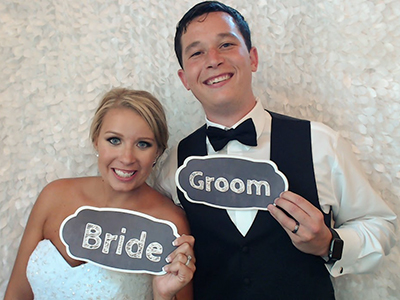 a bride and groom pose for a sweet picture in the photo booth