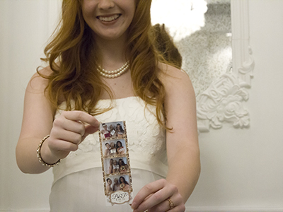 a bride poses with her photo strip